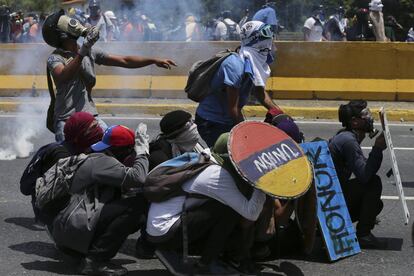 Un grupo de manifestantes lanzan piedras y otros objetos contra los policías antidisturbios.