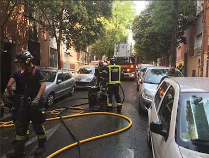 Varios bomberos en Puente de Vallecas tras extinguir un incendio en una vivienda.