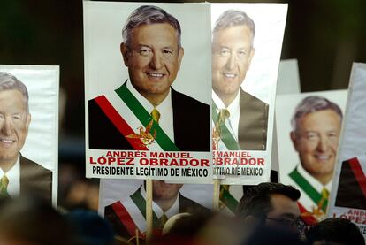 Un grupo de personas con carteles de Andrés Manuel López Obrador.