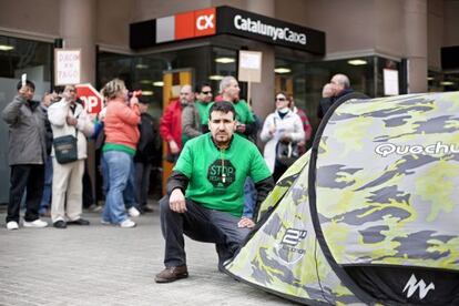 El afectado, César Guerrero, acampado frente a la sucursal de Catalunya Caixa en L’Hospitalet.