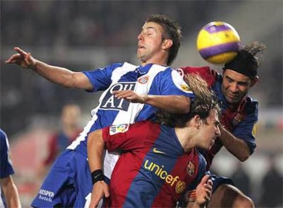 Puyol y Márquez disputan un balón aéreo con Luis García