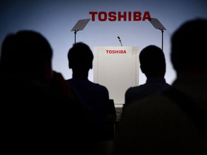 Periodistas se sientan frente al logo de Toshiba en una rueda de prensa, en una imagen de archivo.