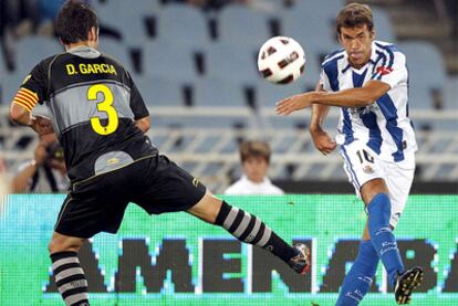 Xabi Prieto centra ante la presencia de David García.