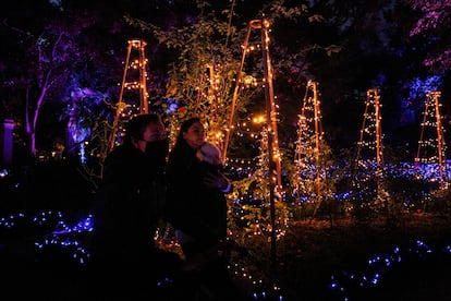 Una familia visita la instalación Naturaleza Encendida en el Real Jardín Botánico de Madrid.