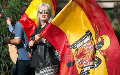 Una manifestante luce una bandera de la España preconstitucional.