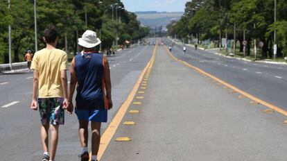 Pessoas caminham pelo Eixão, em Brasília.