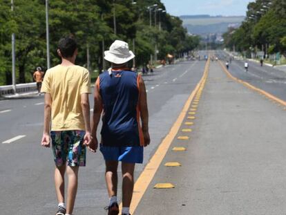 Pessoas caminham pelo Eixão, em Brasília.