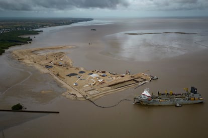A ship creates an artificial island by extracting offshore sand to create a coastal port for offshore oil production at the mouth of the Demerara River in Georgetown, Guyana, Wednesday, April 12, 2023