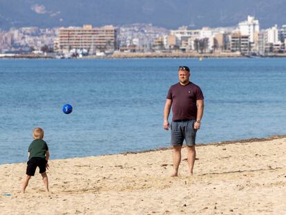 Un hombre juega con su hijo este viernes en la playa de La Palma.