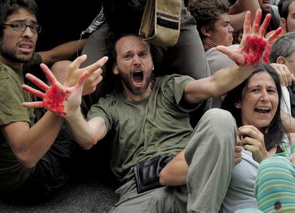 Los manifestantes gritan ante una  carg ade la policía en las cercanías de la plaza Cataluña.