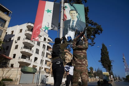 Syrian rebels tear down a poster of Bashar al-Assad in the centre of Aleppo on Saturday.