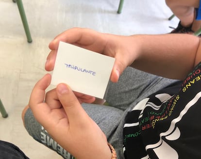 Un alumno sujeta una tarjeta del juego 'Among us' en clase.