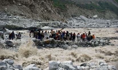 Un grupo de personas intenta ponerse a salvo de la crecida de un r&iacute;o en India, el pasado mes de junio.