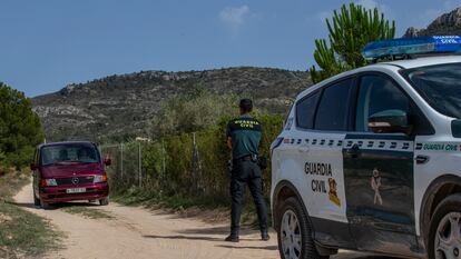 Agentes de la Guardia Civil custodian la salida del vehículo de Instituto Médico Forense por el camino de acceso a la vivienda donde una pareja ha sido hallada muerta, este viernes en Villena (Alicante).