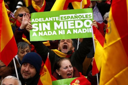 Homem segura um cartaz com frase "Adiante espanhóis, sem medo a nada nem a ninguém" durante o ato na praça de Colón de Madri.