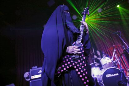 Gisele Marie, a Muslim woman and professional heavy metal musician, plays her Gibson Flying V electric guitar during a concert in Sao Paulo December 16, 2014. Based in Sao Paulo, Marie, 42, is the granddaughter of German Catholics, and converted to Islam several months after her father passed away in 2009. Marie, who wears the Burka, has been fronting her brothers' heavy metal band "Spectrus" since 2012. "People do not expect to see a Muslim woman who uses a Burqa, practices the religion properly and is a professional guitarist who plays in a Heavy Metal band, so many people are shocked by it. But other people are curious and find it interesting, and others think that it is cool, but definitely, many people are shocked," said Marie. Picture taken December 16, 2014. REUTERS/Nacho Doce TPX IMAGES OF THE DAY