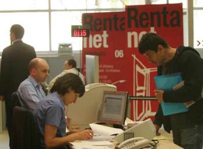 Contribuyentes gestionando la cumplimentación de sus impresos del IRPF en una oficina de Hacienda.