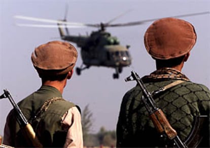 Dos milicianos de la Alianza del Norte contemplan el despegue de un helicóptero.