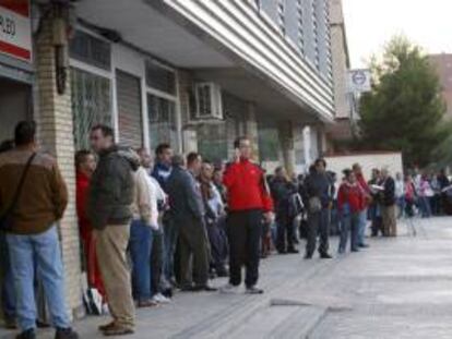 Decenas de personas esperan su turno ante una oficina del INEM en el madrileño barrio de Santa Eugenia. EFE/Archivo