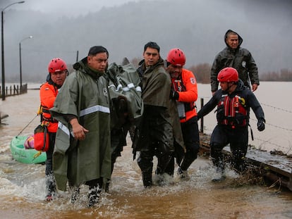 Carabineros y personal de emergencias evacuan a personas tras el desborde del río Pichilo, en la comuna de Arauco, región del Bio Bío (Chile), el 11 de junio.