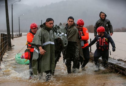 Carabineros y personal de emergencias evacuan a personas tras el desborde del río Pichilo, en la comuna de Arauco, región del Bio Bío (Chile), el 11 de junio.