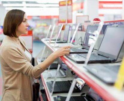 Una mujer observa ordenadores portátiles en Media Markt.