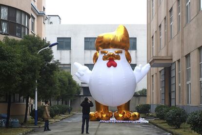 Un hombre fotografía una gallina gigante que representa al presidente electo estadounidense, Donald Trump, en una fábrica en Jianxing, en la provincia de Zheijiang (China).