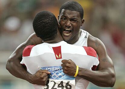 Justin Gatlin  es felicitado por su compatriota Shaw Crawford (de espaldas)  tras su triunfo.