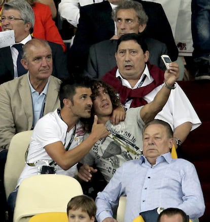 Villa y Puyol se hacen una foto en la grada del estadio, donde han acudido a apoyar a la selección.