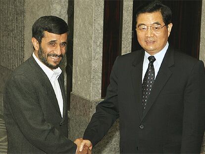 El presidente iraní, Mahmud Ahmadineyad, saluda al presidente chino, Hu Jintao, ayer en Shanghai.