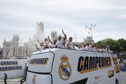 Los jugadores del Real Madrid saludan desde el autobús a los aficionados en la Plaza de Cibeles, este domingo.
