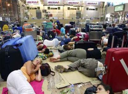 Viajeros duermen en El Prat tras el cierre del aeropuerto en julio.