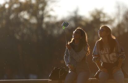 Dos j&oacute;venes en el estanque del Parque del Retiro posan para una fotograf&iacute;a.