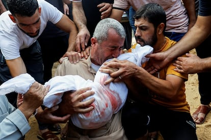 Un hombre sostiene el cadáver de uno de los niños de la familia Al Agha, muerta por uno de los bombardeos de Israel en Jan Yunis. 