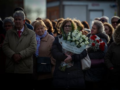 Varias personas con ramos de flores acuden al acto en recuerdo de las víctimas de los atentados del 11-M, celebrado este lunes frente a la estación de Cercanías de Santa Eugenia, Madrid.