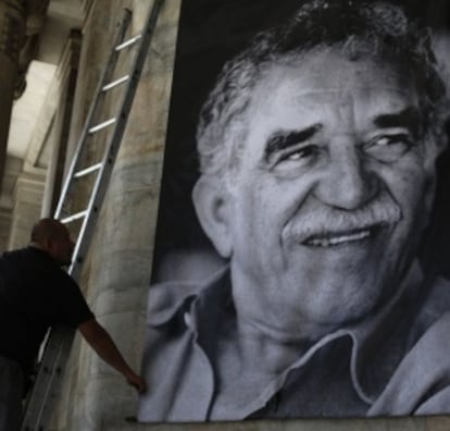 Un trabajador coloca un póster de García Márquez en una pared del Palacio de Bellas Artes de Ciudad de México.