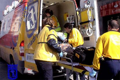 Trabajadores de urgencias meten al agredido en una ambulancia para llevarlo al hospital.