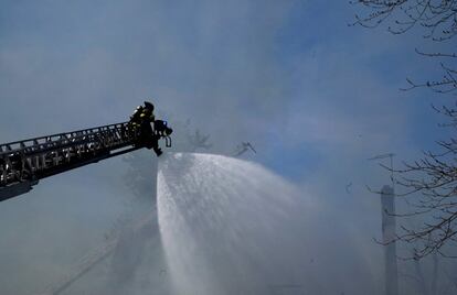 Los bomberos rocían agua sobre el humo del Evergreen Court Home for Adults, en Spring Valley, Nueva York, este martes.