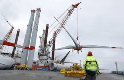 Un obrero observa el traslado de las hélices de uno de los aerogeneradores al barco.
