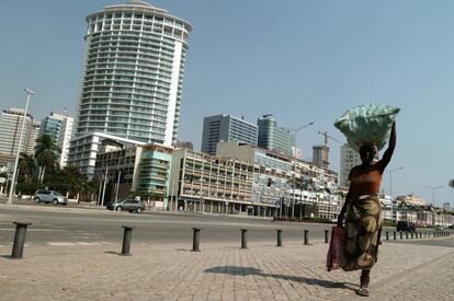 Una mujer transporta una cesta de comida en la cabeza en la capital de Angola, Luanda. Esta ciudad, que en 2015 lideraba la clasificación de Mercer, ha bajado al segundo lugar este año.