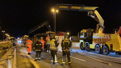 Operarios de la grúa, bomberos y agentes de la Guardia Civil, a primera hora de la mañana durante los trabajos para retirar el camión accidentado en el kilómetro 84 de la M-50.