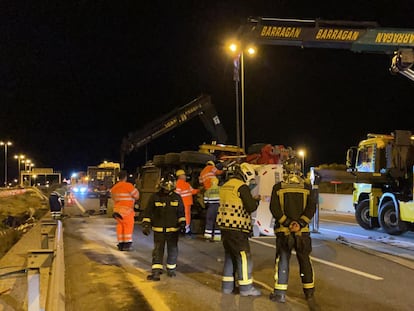 Operarios de la grúa, bomberos y agentes de la Guardia Civil, a primera hora de la mañana durante los trabajos para retirar el camión accidentado en el kilómetro 84 de la M-50.