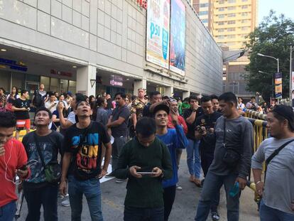 Varios ciudadanos evacuados de un centro comercial en Manila tras el terremoto. 