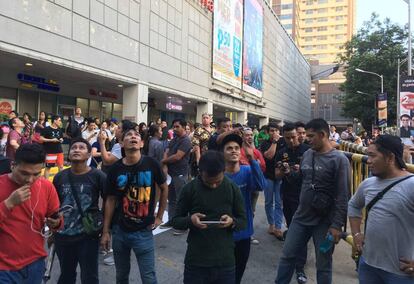 Varios ciudadanos evacuados de un centro comercial en Manila tras el terremoto.