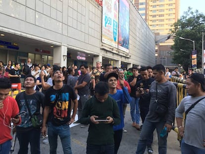 Varios ciudadanos evacuados de un centro comercial en Manila tras el terremoto. 