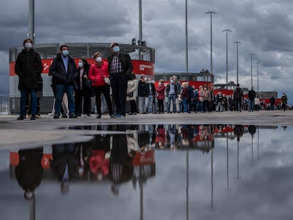 Cientos de personas hacen cola para ponerse la vacuna contra la covid-19 en el estadio Wanda Metropolitano de Madrid, este viernes.