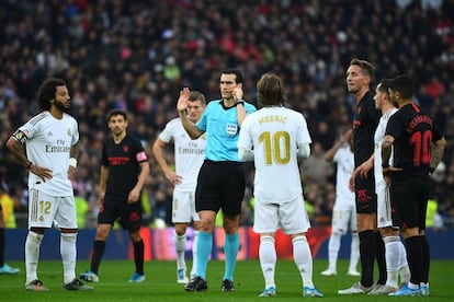 El árbitro Juan Martínez Munuera, rodeado de jugadores antes de anular el gol del Sevilla marcado por Jong.
