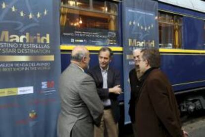 Fotografía facilitada por la Comunidad de Madrid del consejero de Economía, Enrique Osorio (2i), junto a uno de los cinco coches del tren Prestige, con casi un siglo de vida, que servirá como soporte para promocionar el turismo en la región como parte de la campaña "Madrid, destino 7 estrellas". EFE/Comunidad de Madrid