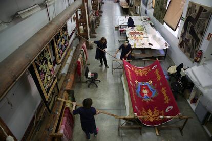 Trabajadores extienden un tapiz recién terminado.