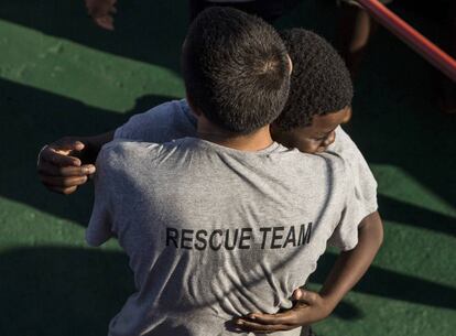 Khingsley Dokowada, de 9 años de la República Centroafricana, abraza a un miembro de la tripulación a bordo del barco Open Arms antes de llegar al puerto de Barcelona, el 4 de julio de 2018.